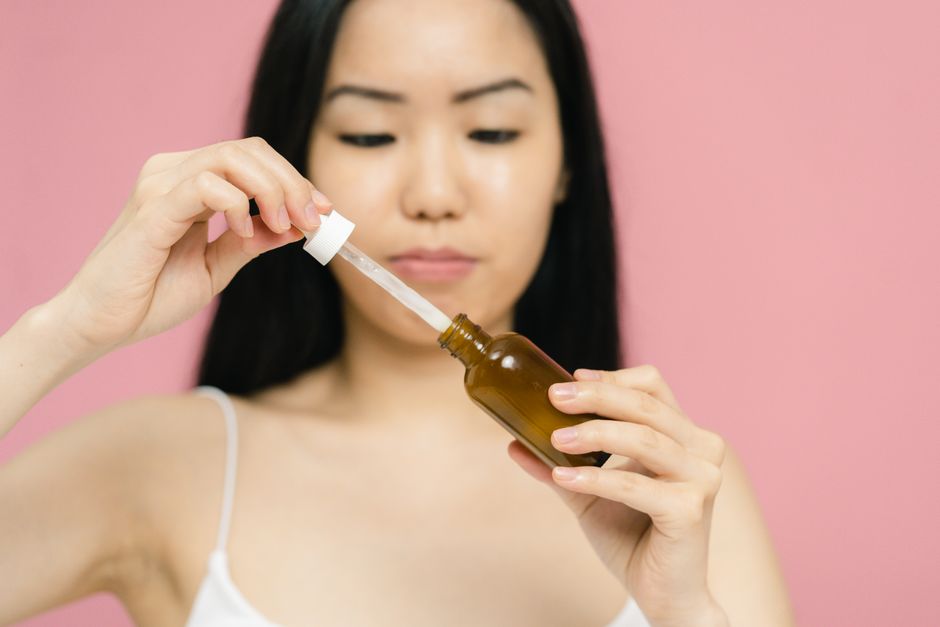 여성이 리프팅 세럼을 얼굴에 바르는 모습